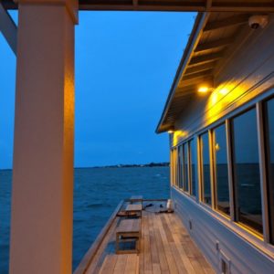 Dark sky 590nm Amber LED wall packs over by a deck over the ocean